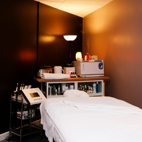 Spa or massage room with bed, towels, and various items on a counter.