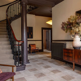 Staircase and hallway with a wooden sideboard and decorative items.