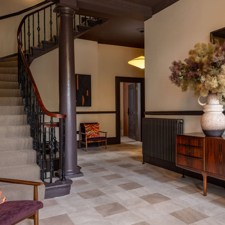 Staircase and hallway with a wooden sideboard and decorative items.